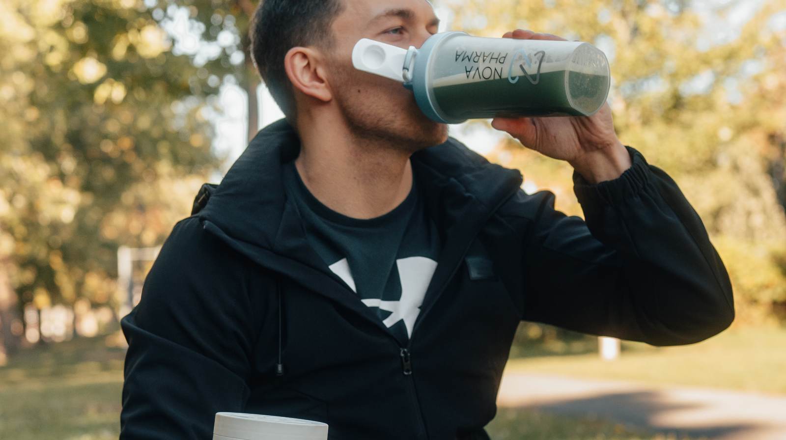 Un homme qui boit des greens & berries de Nova pharma dans une shaker Nova Pharma